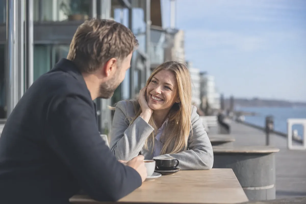 To voksne på afslappet kaffedate ved Helsingørs havnefront med udsyn mod vandet